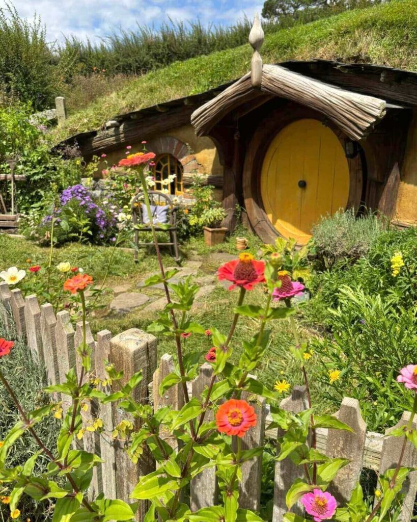 Hobbiton house with colourful flowers in New Zealand