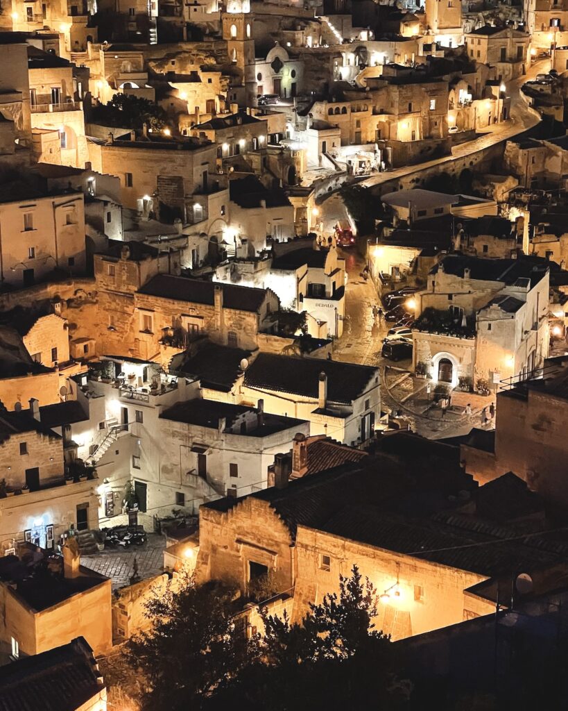 Matera buildings lit up at night with warm orange glow