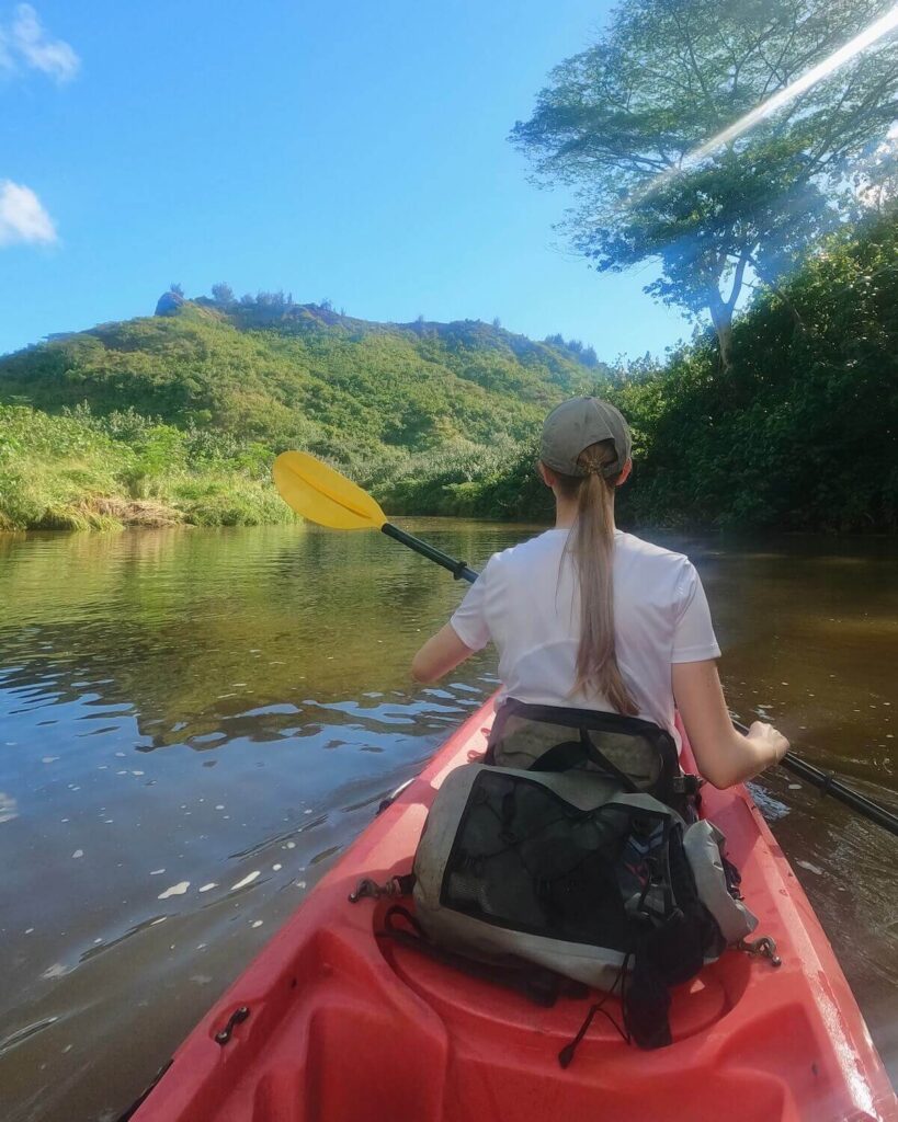 Samantha paddling in kayak on Wailua River on sunny day