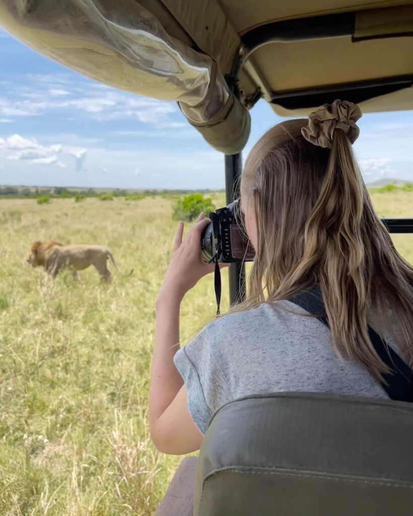 Samantha photographing lion in Masai Mara from safari jeep