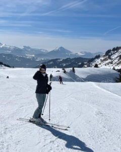 Skiing in France - skier posing poles on mountain on blue sky day