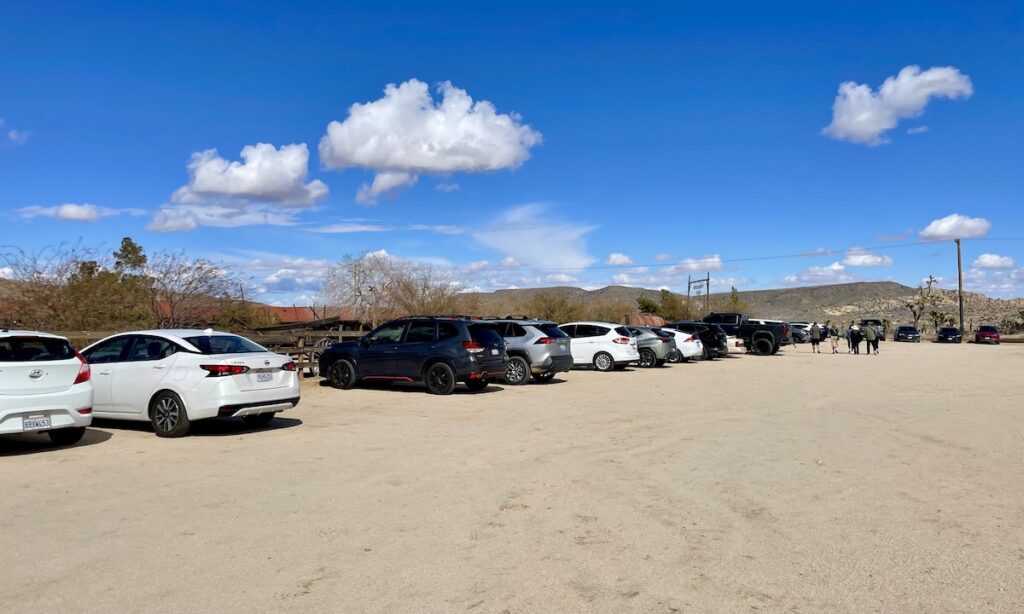 Car park in Pioneertown - filled with around 15 cars shown on dirt