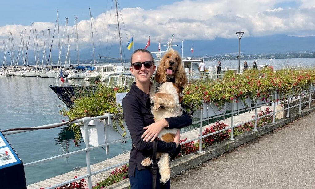Me holding my cocker spaniel at Yvoire port with flowers behind us