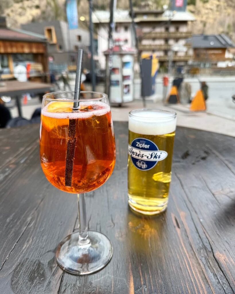 Aperol Spritz and beer on wooden table in Solden town at Marco's bar