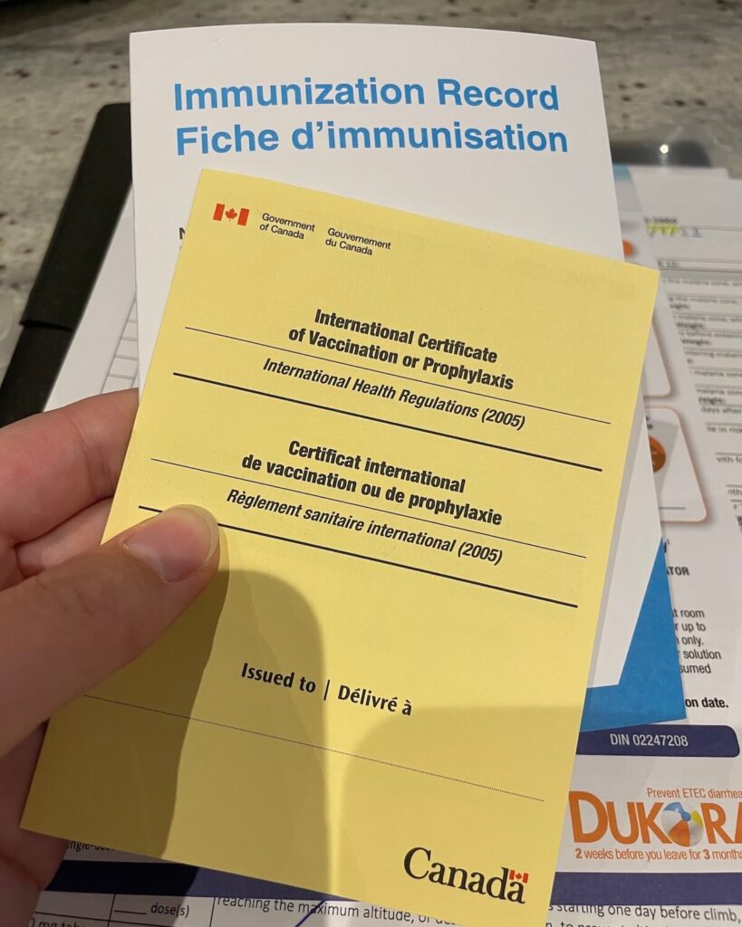 Yellow vaccination booklet from Canada with immunization paper behind