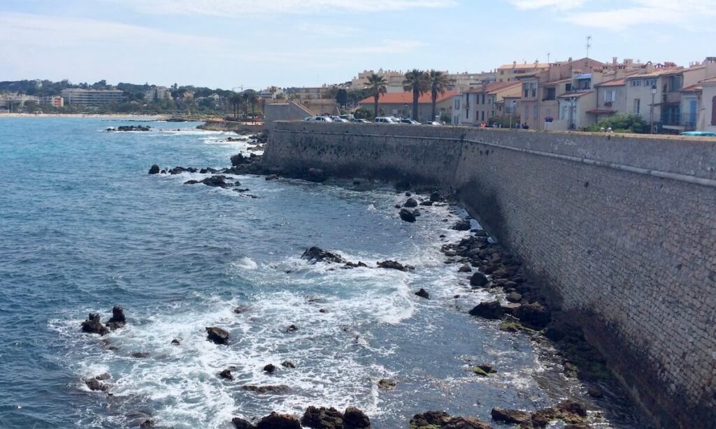 Antibes coastal walk with rocks in water and houses dotted along path