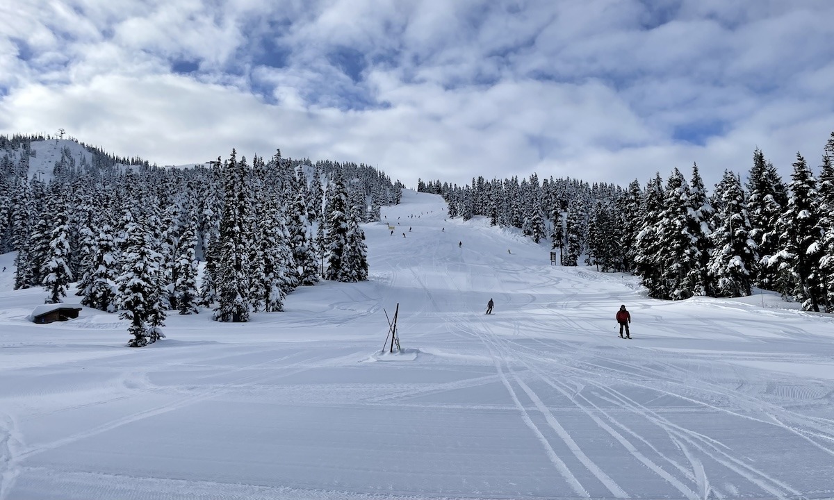 Wide open run at Whistler Blackcomb with a few skiers spread out and fresh snow