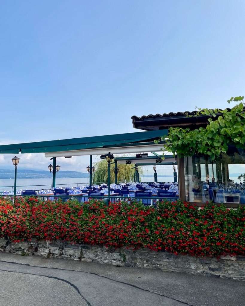 Hotel Restaurant du Port in Yvoire outdoor dining with flowers on lakefront