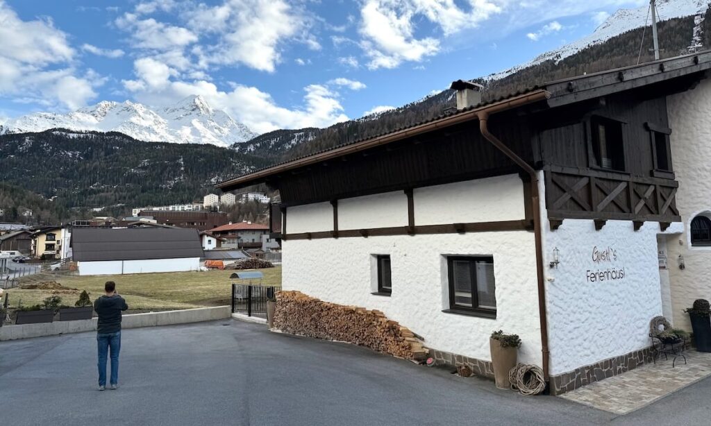 Gustl’s Ferienhäusl guesthouse with view of snowy mountains and field behind