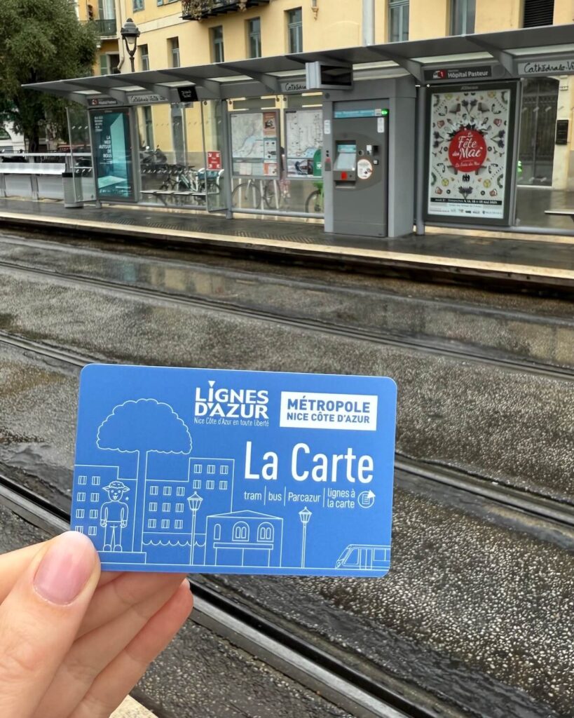 Lignes D'azur la carte public transport card held in front of tram tracks in Nice