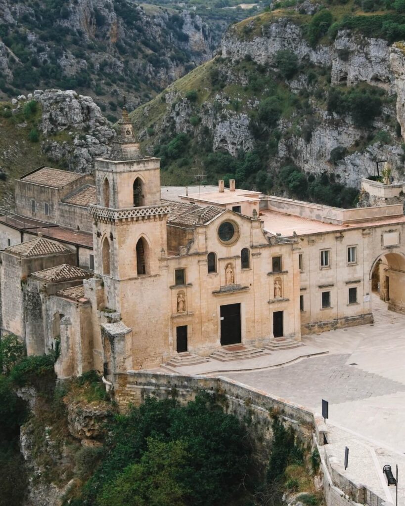 Chiesa di San Pietro Caveoso Matera with view of grassy and rocky ravine as backdrop