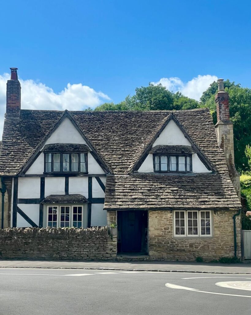 Lacock cottage with traditional white paint and black lines and a tile roof with chimneys