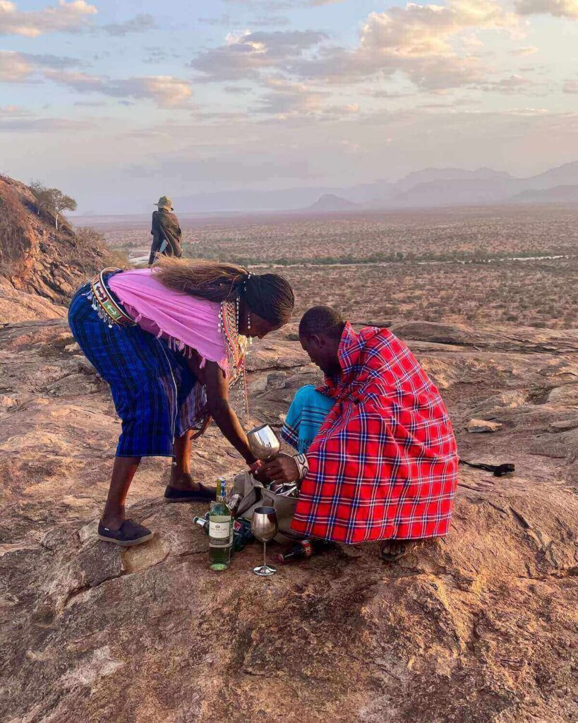 Lodge staff preparing drinks for sundowner on top of rocky hill - from Sasaab Lodge in Kenya