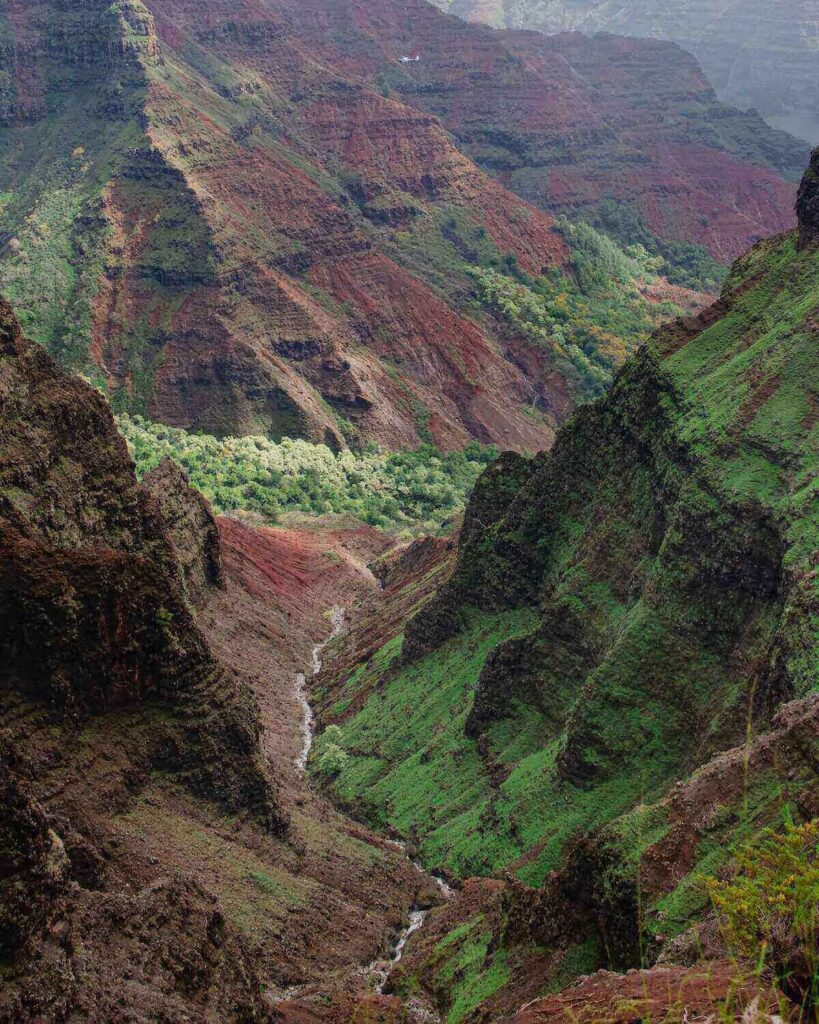 Pu’u Hinahina Lookout with view of waterfall and stream at Waimea Canyon in Kauai on foggy day