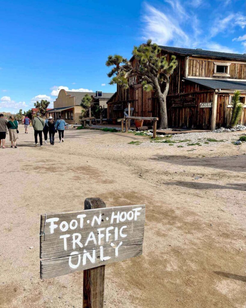 Mane Street with wooden buildings and Joshua Trees and sign with Foot n Hoof traffic only sign