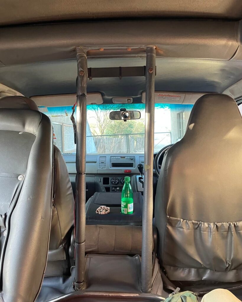 Inside of Nairobi National Park tour vehicle with beige leather seats and supports in centre of car