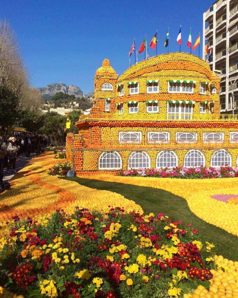 Building made of lemons and oranges with flower and flags to decorate and blue sky in Menton France
