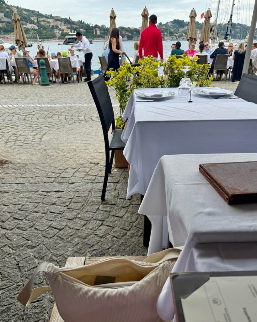 Lunch at La Mere Germaine in Villefranche Sur Met - diners eating outside with white tablecloths next to port