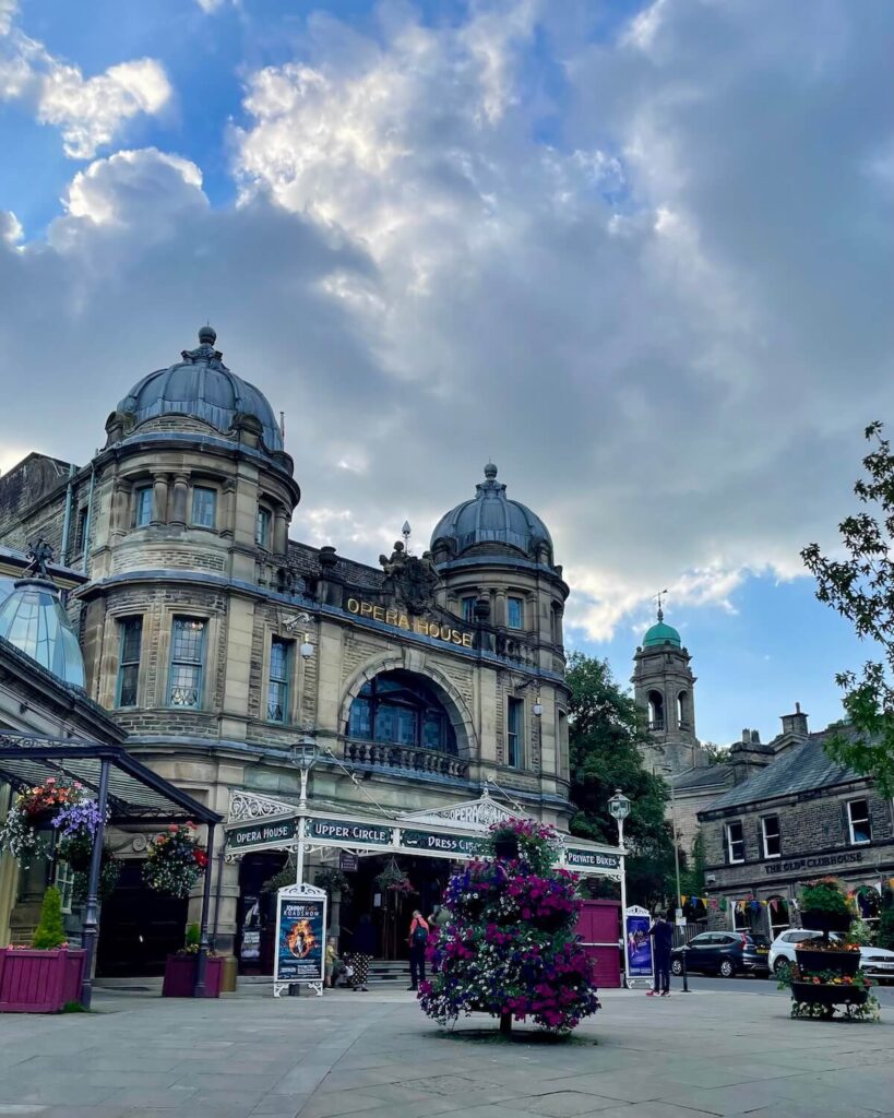 Opera House building in Buxton in Pavilion Gardens with colourful flowers displayed out the front of the old building