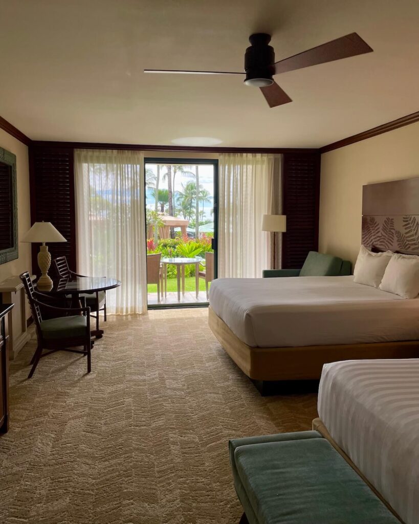Grand Hyatt Kauai Resort and Spa bedroom - 2 double beds and partial ocean view towards the pool with beige carpet and curtains